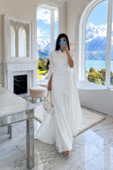 Vestido maxi branco até ao chão, com decote em V, mangas tipo capa e cintura franzida