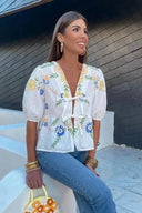 Blusa peplum con fiocco floreale