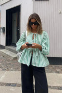 Blusa corta verde a righe con maniche a sbuffo, peplo e fiocco