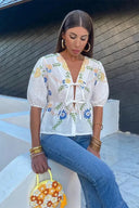 Blusa peplum con fiocco floreale